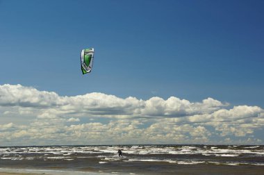 Yaz güneşli bir gün ve Riga Körfezi dalgalarında uçurtma sörfü müsabakaları