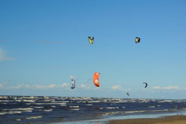 Yaz güneşli bir gün ve Riga Körfezi dalgalarında uçurtma sörfü müsabakaları