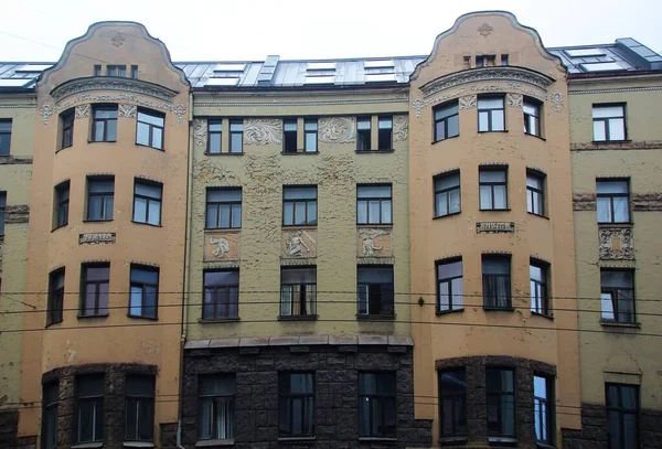 Riga 'nın merkez caddelerinden birinde ulusal romantizm tarzında bir konut kapısı olan ön cephenin bir parçası.