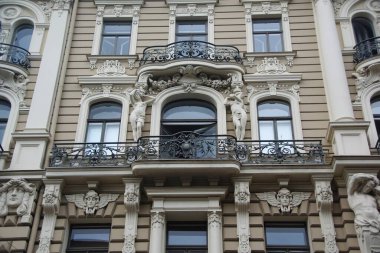 Riga 'nın merkez caddelerinden birinde ulusal romantizm tarzında bir konut kapısı olan ön cephenin bir parçası.