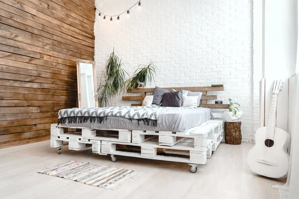 Moderno design di arredamento studio con letto pallet, impianto in vaso, fotocamera retrò e chitarra — Foto Stock