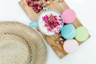 Hasır şapka ve aroma kapuçino Fransız lezzetli macarons çerezler ile mavi fincan Üstten Görünüm