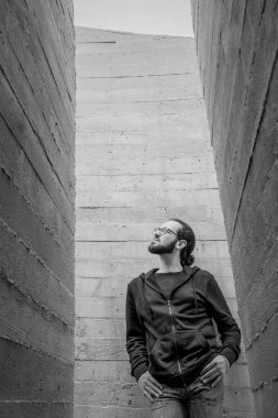 Genç yakışıklı adam duvara yakın ayakta beyaz ve yukarı bak. Adam kot moda giyim gülümseyen portresi