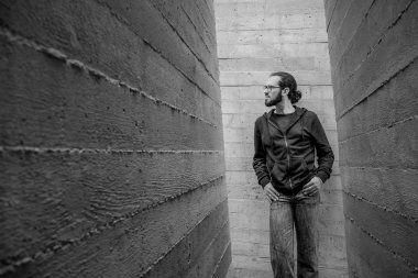 Genç yakışıklı adam duvara yakın ayakta beyaz ve yukarı bak. Adam kot moda giyim gülümseyen portresi