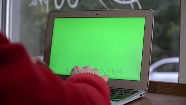 Дівчина використовує ноутбук, що сидить всередині ресторану кафе та яскраві інтер'єри з дерев'яними меблями та червоними стільцями . — стокове відео