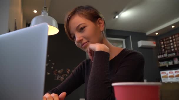 女孩打字上笔记本电脑键盘在咖啡厅 — 图库视频影像