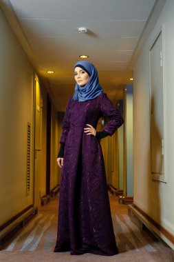Genç Müslüman kadın otel koridorda duran trendy İslami giyim