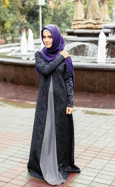 Schöne muslimische Frau im modernen islamischen Kleid spazieren in einem Stadtpark — Stockfoto