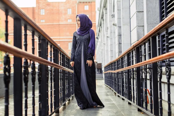 Modern Muslim woman in beautiful Eastern dress standing on the background of the hotel — Stock Photo, Image