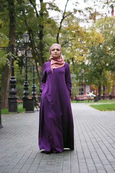 Wanita muslim yang cantik dalam pakaian Islam modern berjalan di taman kota — Stok Foto