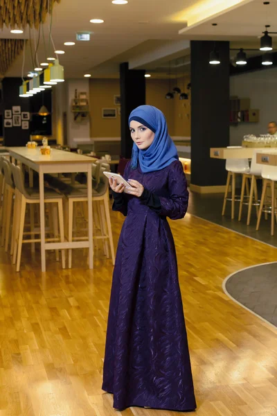 Красивая мусульманка с электронным планшетом в руках, в вестибюле отеля — стоковое фото