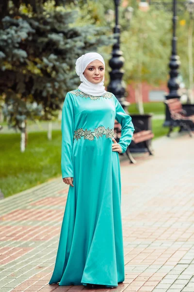 Wanita Muslim dalam gaun oriental dan saputangan putih di kepalanya di taman — Stok Foto