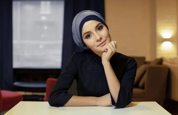 Портрет красивой молодой мусульманки, сидящей за столом — стоковое фото
