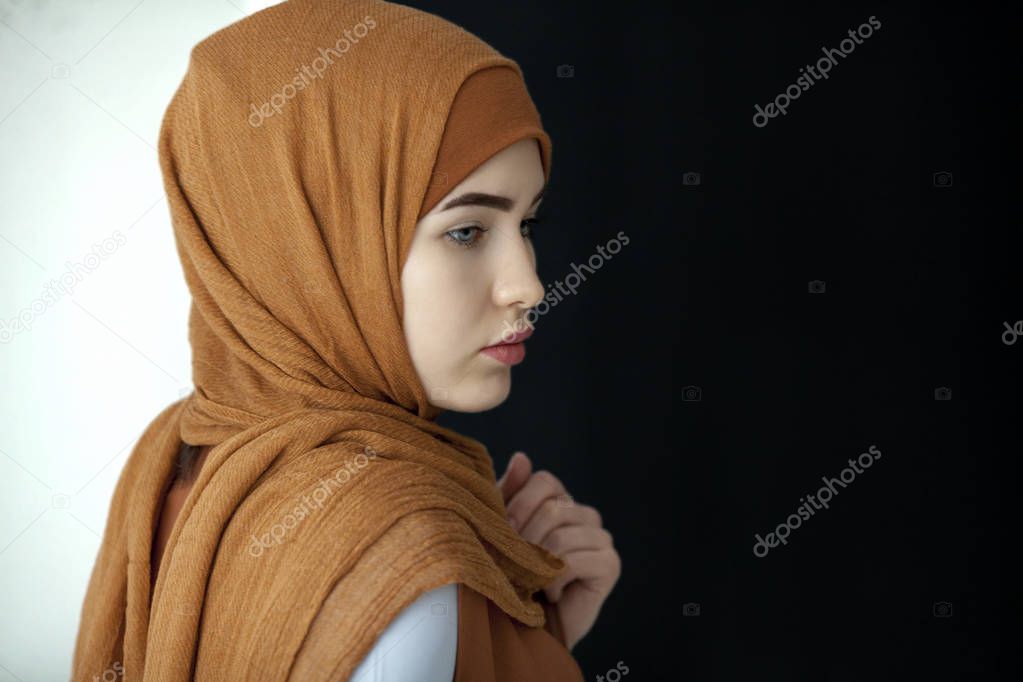 Portrait of a beautiful Muslim woman in a green scarf covering her head