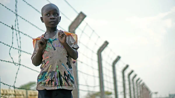 Lusaka, Sambia - 24. September 2014: Afrikanischer Junge steht auf einem Hintergrund aus Stacheldraht entlang der Eisenbahnlinie — Stockfoto