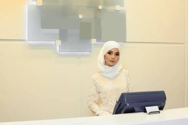 Красивая мусульманка, стоящая за стойкой регистрации в отеле — стоковое фото