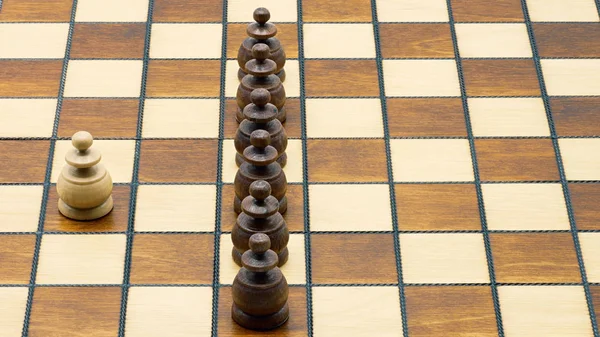 Koncepcja Underdog: Jeden biały pionek stojący przeciwko Black Pawns — Zdjęcie stockowe