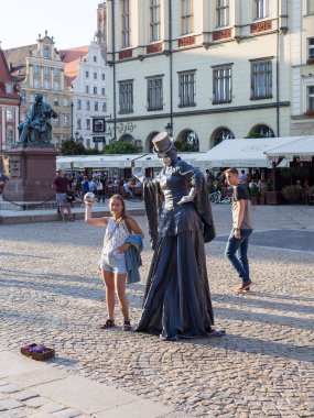 Wroclaw 'daki Rynek Pazar Meydanı' nda Turist Kız ile Pandomimci Sokak Sanatçısı