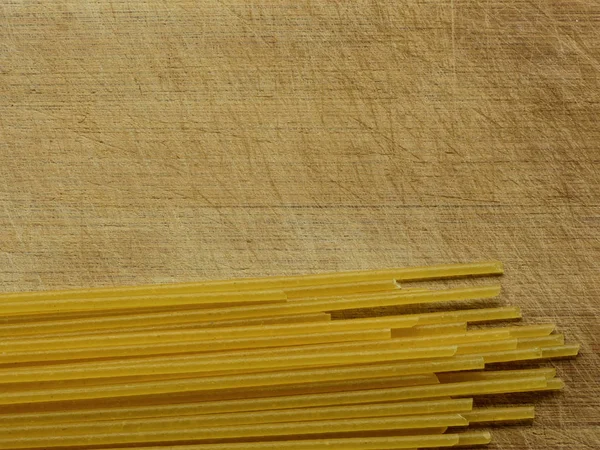 Close-up of Uncooked Spaghetti On A Scratched Wooden Board, Top View — Stock Photo, Image