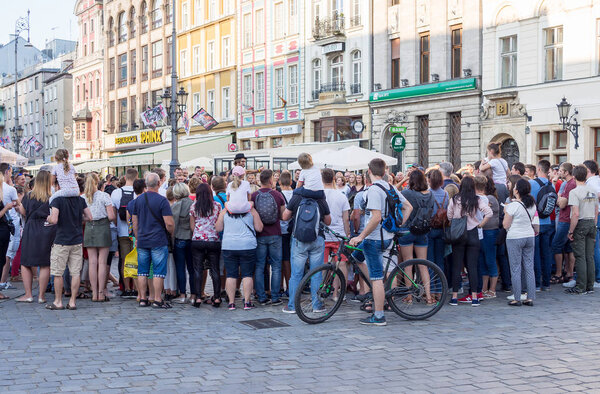 Уличный исполнитель с аудиторией на Рыночной площади во Вроцлаве

