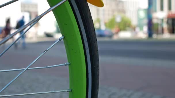 Roue à rayons verts d'une bicyclette avec circulation en arrière-plan, Focus sélectionné — Video