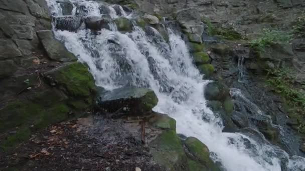 Zeitlupe eines kleinen Wasserfalls mit bemoosten Felsen — Stockvideo