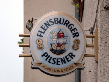 Advertisement: Logo of German Flensburger Pilsener Beer In Berlin, Germany