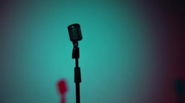 Profesyonel konser klasik mikrofon kaydı için ya da boş retro kulübünde seyircilerle konuşmak için. Sahne ışıklarının çok renkli gölgeleri koyu renk arkaplanda pürüzsüz.