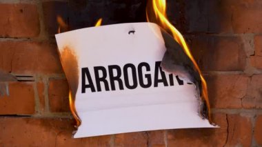 Beyaz bir A4 tablosundaki yazı turuncu bir duvarın arka planına karşı. Üzerinde 