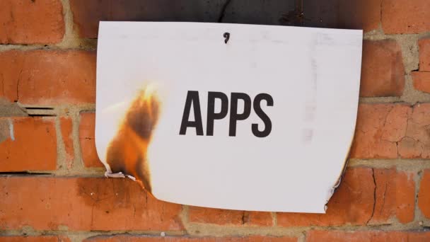 白色A4尺寸薄片上的题词 背景是橙色的砖墙 纸的黑字Apps燃烧 烟雾和变成灰烬 业务概念 — 图库视频影像