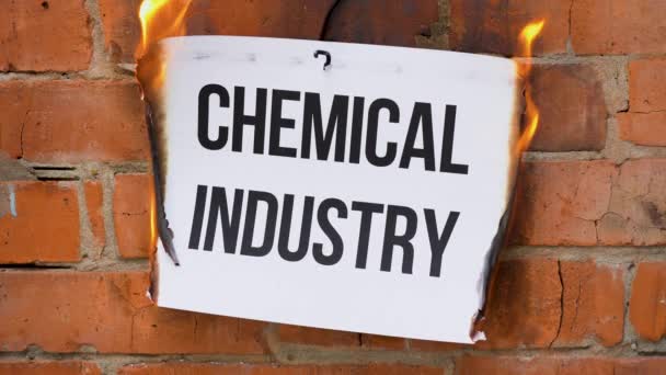 白色A4尺寸薄片上的题词 背景是橙色的砖墙 纸上写着 化学工业 这个黑字 化为灰烬 业务概念 — 图库视频影像
