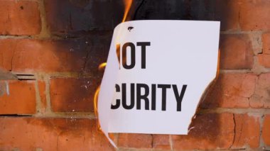 Beyaz bir A4 tablosundaki yazı turuncu bir duvarın arka planına karşı. Üzerinde 