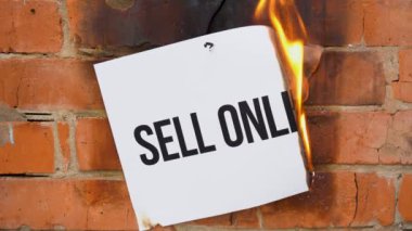 Beyaz bir A4 tablosundaki yazı turuncu bir duvarın arka planına karşı. Üzerinde 