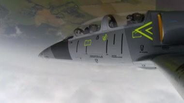 Gri savaş uçağı bulutlu bir gökyüzüne karşı Split S manevrası yapıyor. Tehlikeli bir numara. Uçak pilotu ters çevrilmiş yarım rulo ile sert bir dönüş gerçekleştirir. Sol kanattan yaklaş. Erobatik.