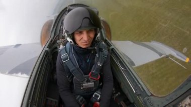 Gri mavi avcı uçağı yerden hızla ve alçaktan uçar ve koyu bulutlu bir gökyüzüne karşı sola döner. Yeni pilotu uçaktaki uçuşlar için hazırlıyorum. Aşırı yüklenme yaşayan bir adam, o kötüdür..