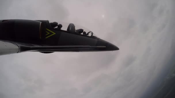 訓練用のグレーブルーのジェット飛行機は 暗い曇りの曇った空に向かって鼻を飛んでいきます カメラの上に水のドロップグライド 右側の翼を上から見る — ストック動画