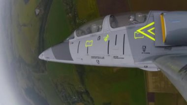 Gri mavi savaş uçağı bulutlu bir gökyüzüne karşı üçlü dönüş manevrası yapıyor. Uçak boylamsal eksen 360 etrafında döner. Sol kanattan yaklaş. Aerobatik biçim.