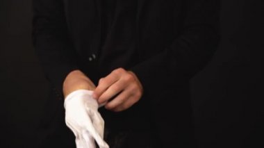 Elinde saati olan beyaz bir adam koyu bir arka planda güzel beyaz eldivenler giyer. Siyah ceketli ve siyah tişörtlü bir adamın güçlü elleri. Uzun zaman oldu..