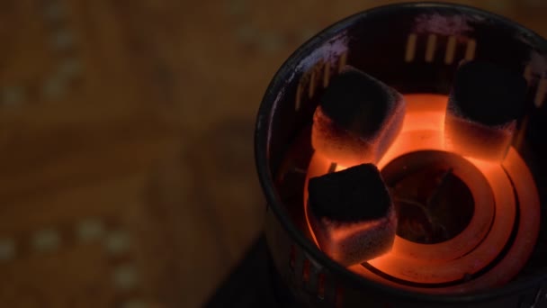 古いレトロな電気キャンプストーブの上で石炭が混練され 笑顔です 3つの黒い正方形の石炭が横になり ぼやけた暗い背景の上に赤い熱いオレンジ色の螺旋状に燃えます トップ表示 — ストック動画