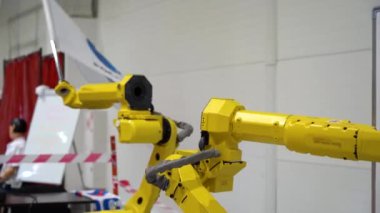 Enstitü ya da laboratuvar robot makineleri geliştiriyor. Üretimi otomatikleştirmek için özel bir teknoloji. Tekniğin testi. Sarı makine elleri sağa sola dönüyor, bayrak sallıyor. Yenilik
