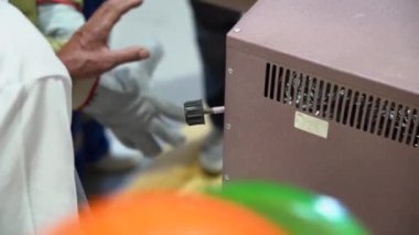 Erkek işçi kalın koruyucu kaynak eldivenleri giyer, takım elbise giyer, kutuyu açar, bir sürü kaynak elektrodu olan konteynırları çıkarır. Manzarayı kapat. İçeride. Şef gözlük takıyor..