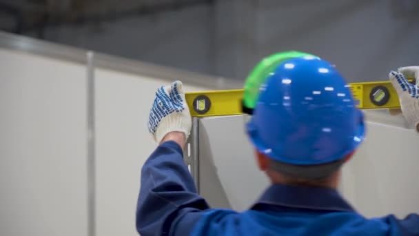 ロシア 8月07 2019 白人労働者男性は工場を背景に職場の研削盤に金属棒を研削します 1人の男は火花から頭の上に特別な保護緑のジャケット 白い顔のマスク 赤いヘルメットを着用 — ストック動画