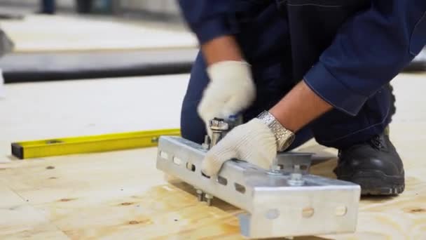 Een Mannelijke Arbeider Draagt Overalls Witte Handschoenen Hurkend Houten Vloer — Stockvideo