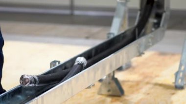 Kesilmiş, bağlanmamış, gümüş metal kutuda duran siyah elektrikli bakır kablolar, elektrik paneline yerleştiriliyor, kablo fabrikanın arka plan görüntüsüne kurulum için hazır. İnsanlar olmadan.