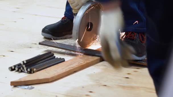Robotnik Stawia Kilka Prętów Metalowych Okuć Drewnianym Pręcie Dociskanych Stopą — Wideo stockowe