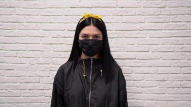 Uzun siyah saçlı, yüzü koruyucu tıbbi maske takan beyaz tuğla duvarlı güzel bir kızdan korkuyordu. Koronavirüsten korkuyor. El ele tutuşarak.