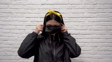 Siyah ceketli çekici, beyaz saçlı, beyaz duvarlı, virüsten yüzünde koruyucu bir maske takan beyaz saçlı bir kız. Covid 19 Coronavirus Koruma Konsepti.