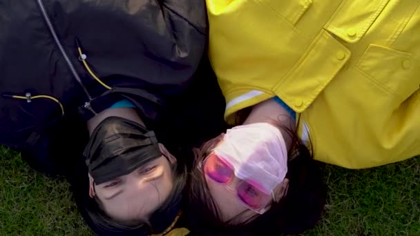 Schöne Kaukasische Mädchen Schwarzen Und Rosafarbenen Medizinischen Schutzmasken Liegen Auf — Stockvideo