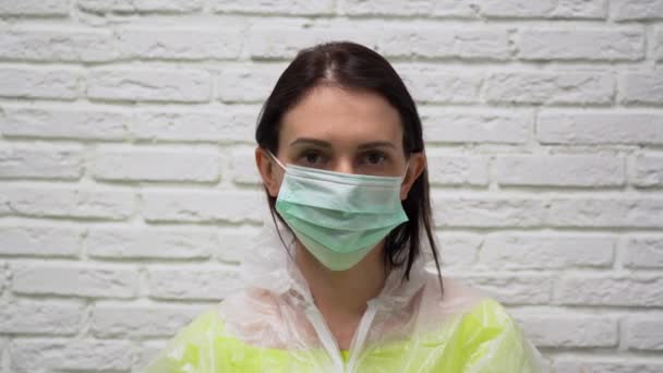 방호복을 장갑을 귀여운 여자가 인공호흡기와 의료용 마스크를 얼굴에 붙이고 배경에 — 비디오