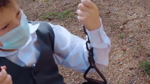 Einsames Kind Schulanzug Mit Medizinischer Schutzmaske Auf Dem Gesicht Reitet — Stockvideo